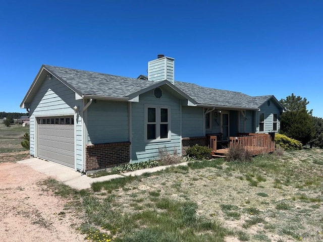 15840 Teak Pl, Elbert, CO 80106 - exterior space with a chimney, brick siding, dirt driveway, a shingled roof, and an attached garage