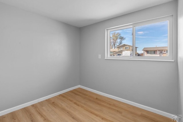 empty room featuring wood finished floors and baseboards