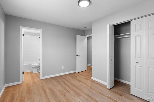 unfurnished bedroom featuring light wood-style floors, a closet, and baseboards