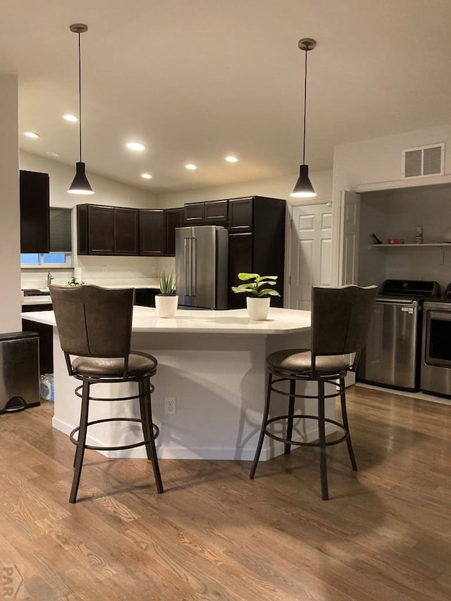 47 S Jibbsam Way, Pueblo West, CO 81007 - kitchen featuring washing machine and clothes dryer, light countertops, high end fridge, wood finished floors, and a breakfast bar