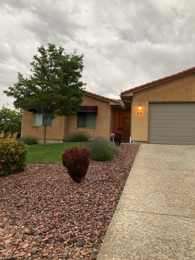 47 S Jibbsam Way, Pueblo West, CO 81007 - ranch-style house with stucco siding, a tiled roof, an attached garage, and concrete driveway
