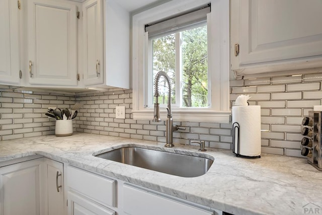 411 Olive St, Colorado Springs, CO 80904 - kitchen featuring a sink, backsplash, white cabinetry, and light stone countertops