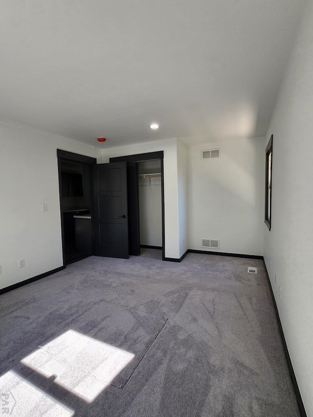 unfurnished bedroom with light colored carpet, visible vents, and baseboards