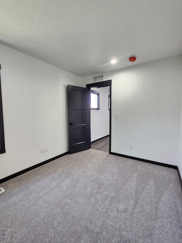 spare room featuring recessed lighting, carpet flooring, visible vents, and baseboards