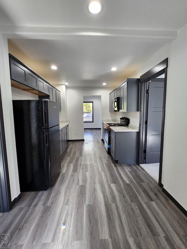 kitchen with black appliances, light countertops, dark wood-type flooring, and gray cabinetry