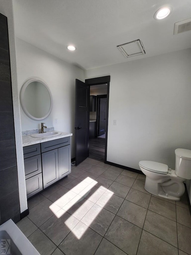 bathroom featuring recessed lighting, toilet, vanity, tile patterned flooring, and baseboards