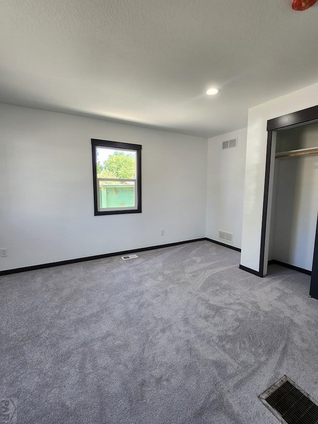 unfurnished bedroom with baseboards, visible vents, and light colored carpet