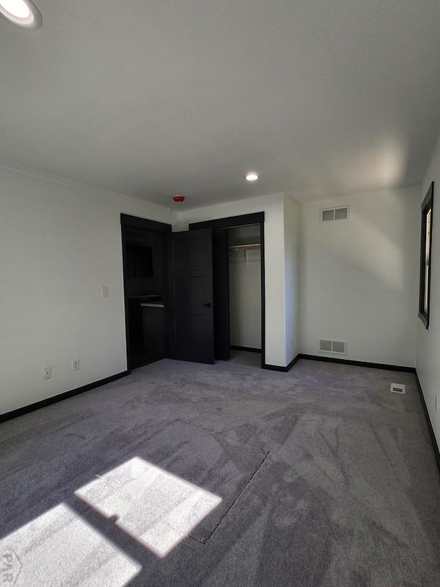 unfurnished bedroom featuring carpet, visible vents, and baseboards