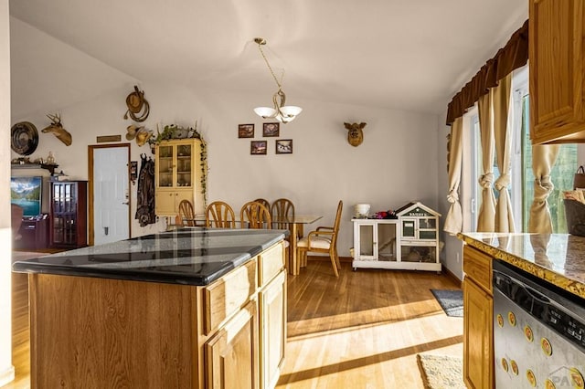 kitchen featuring brown cabinets, dark stone counters, light wood finished floors, dishwasher, and a chandelier