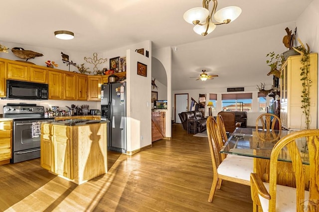 kitchen featuring refrigerator with ice dispenser, stainless steel electric range, black microwave, and wood finished floors