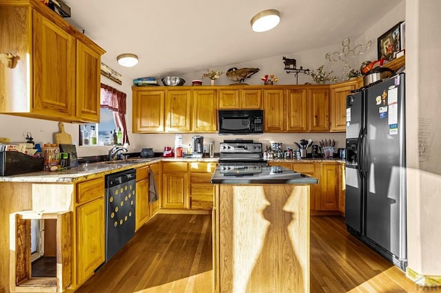 kitchen featuring vaulted ceiling, dark wood-style floors, appliances with stainless steel finishes, and a center island