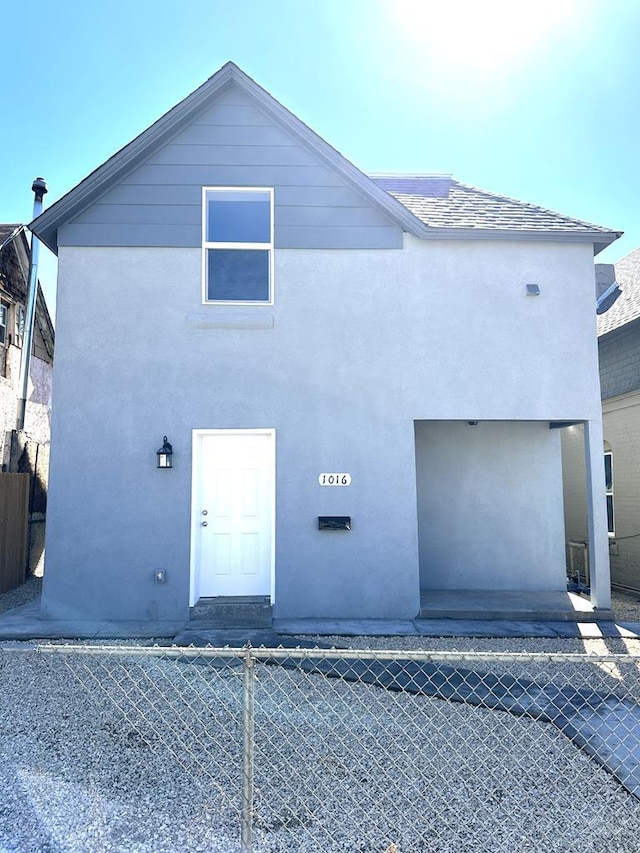 view of front of home featuring fence and stucco siding