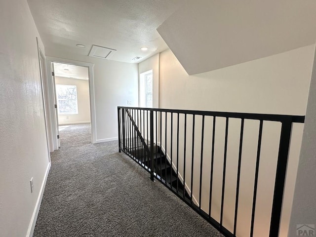 1016 E 10th St, Pueblo, CO 81001 - corridor with visible vents, an upstairs landing, a textured ceiling, carpet, and baseboards