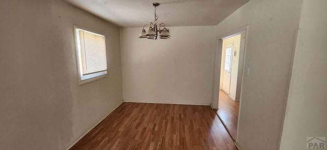 interior space featuring an inviting chandelier, baseboards, and wood finished floors