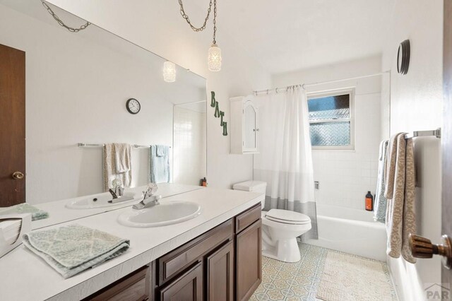 bathroom featuring toilet, shower / bath combo with shower curtain, and vanity