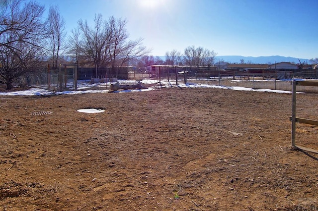 view of yard featuring a rural view, a mountain view, and fence