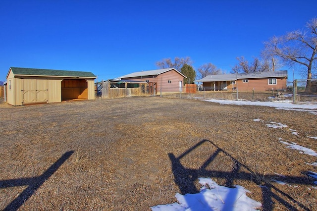 view of yard featuring fence, an outbuilding, and an outdoor structure