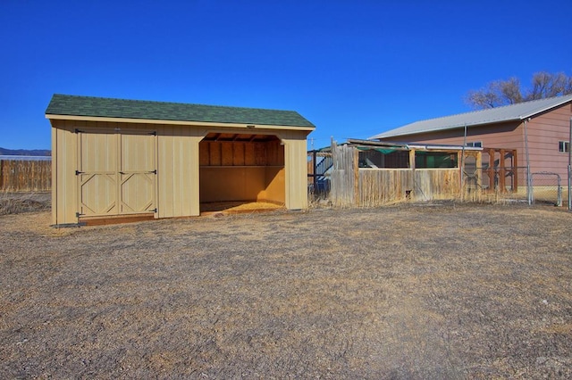 view of outdoor structure featuring fence and an outdoor structure