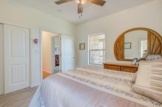 bedroom with baseboards, a ceiling fan, and light colored carpet