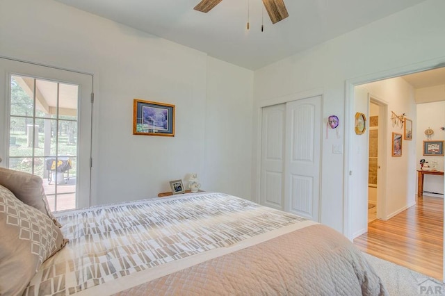 bedroom featuring access to exterior, ceiling fan, a closet, and wood finished floors