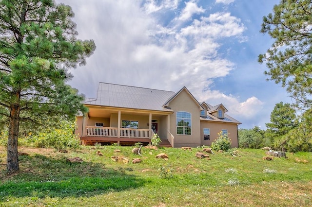 view of front of house featuring a front yard, metal roof, and stucco siding