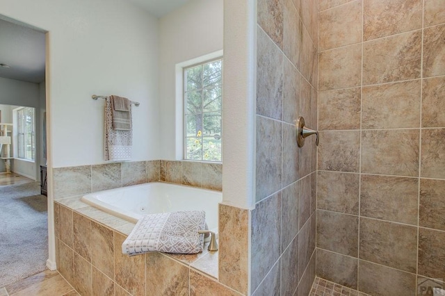 full bath with a tile shower and a garden tub