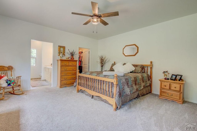 carpeted bedroom with ceiling fan, a spacious closet, a closet, and ensuite bathroom