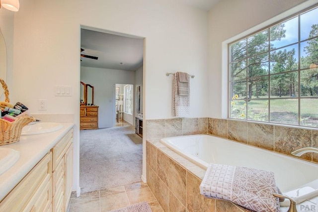 bathroom with double vanity, a sink, a bath, and tile patterned floors