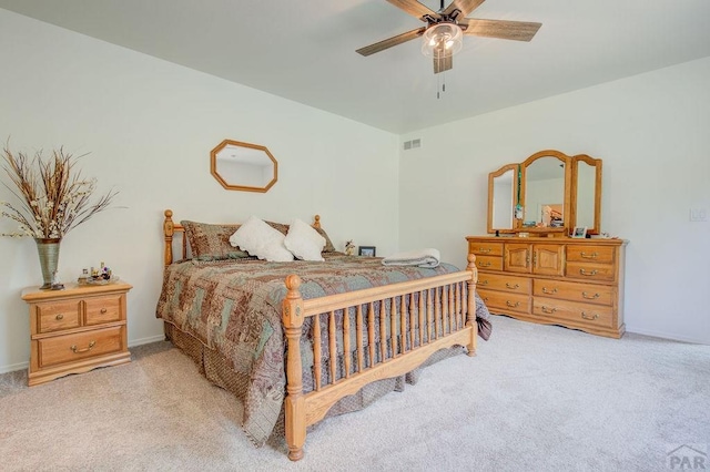 bedroom with baseboards, a ceiling fan, visible vents, and light colored carpet