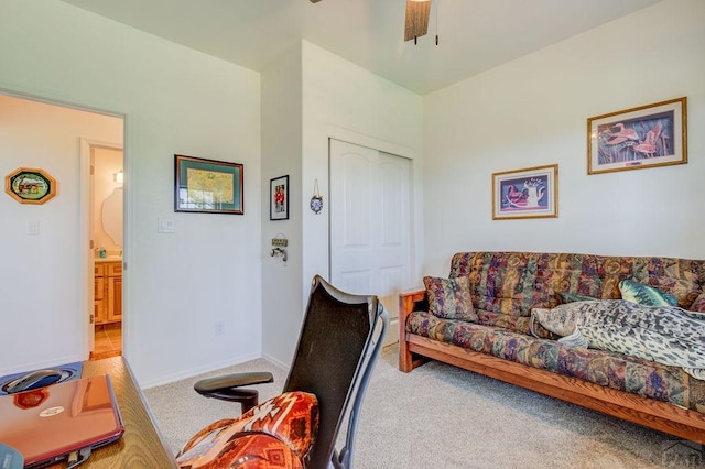 living room with carpet, baseboards, and a ceiling fan