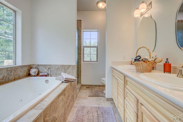 bathroom featuring a healthy amount of sunlight, a sink, toilet, and double vanity