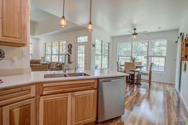 kitchen featuring a ceiling fan, wood finished floors, light countertops, stainless steel dishwasher, and a sink