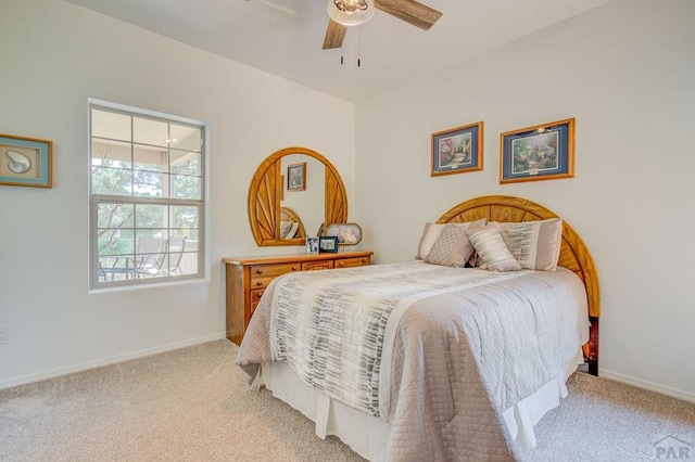 bedroom featuring light carpet, a ceiling fan, and baseboards