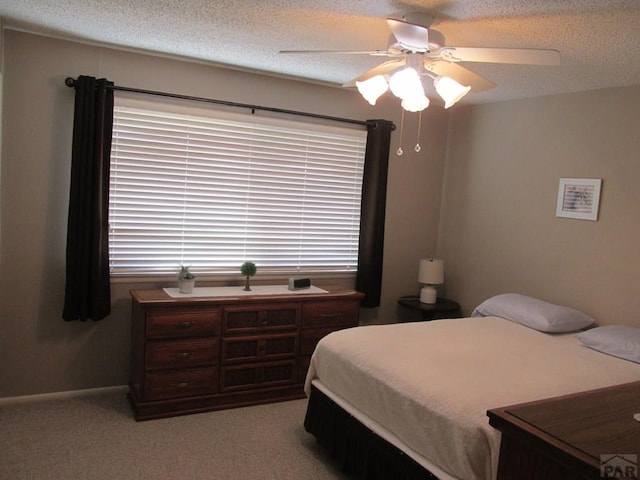 1520 Lexington Rd, Pueblo, CO 81001 - carpeted bedroom featuring multiple windows, a textured ceiling, baseboards, and ceiling fan