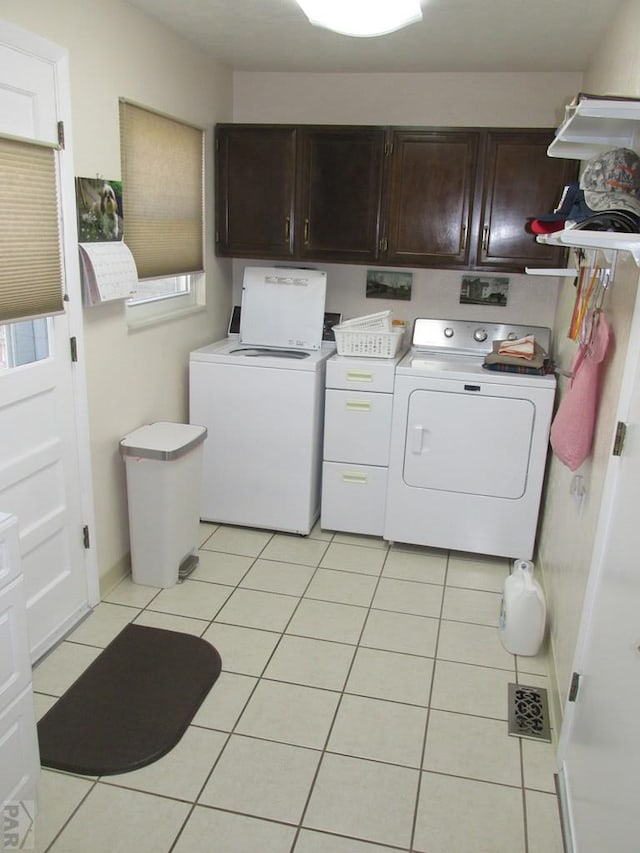 1520 Lexington Rd, Pueblo, CO 81001 - laundry area featuring cabinet space, light tile patterned floors, washing machine and dryer, and visible vents