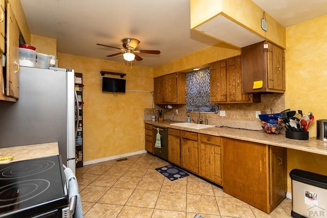 kitchen featuring brown cabinets, stainless steel appliances, light countertops, a ceiling fan, and a sink