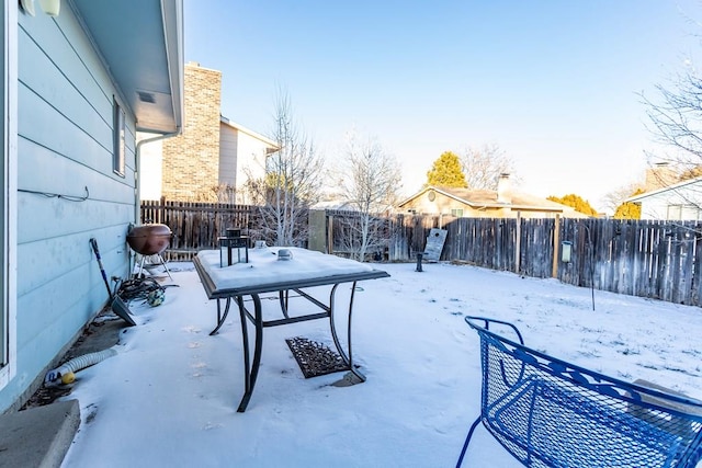 snowy yard with a fenced backyard