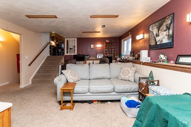 living room with carpet floors, baseboards, and stairs