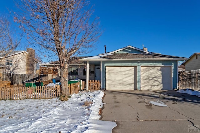 single story home featuring a garage, driveway, fence, and brick siding