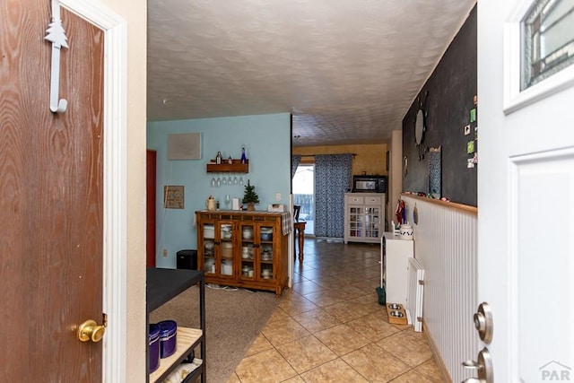 foyer with light tile patterned floors and a textured ceiling