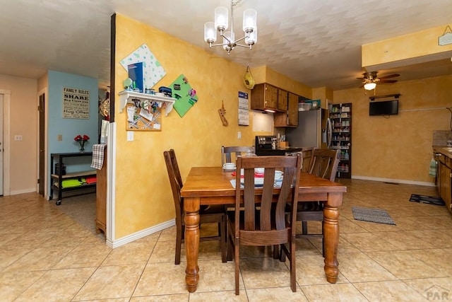 dining room with light tile patterned flooring, baseboards, and ceiling fan with notable chandelier