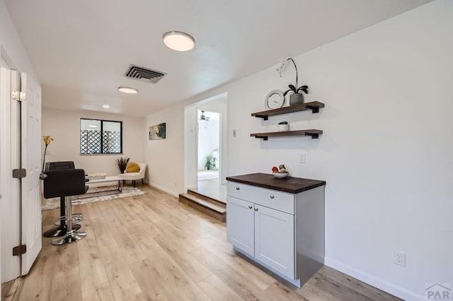 interior space featuring light wood-style floors, baseboards, and visible vents