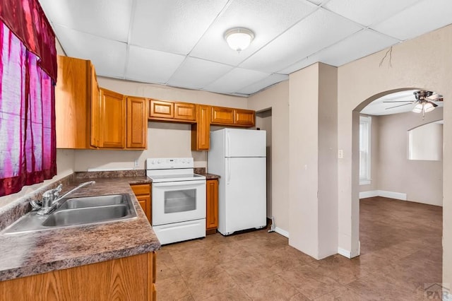 935 Spruce St, Pueblo, CO 81005 - kitchen featuring white appliances, a paneled ceiling, arched walkways, dark countertops, and a ceiling fan