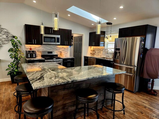 1044 S Los Charros Dr, Pueblo West, CO 81007 - kitchen with a sink, lofted ceiling with skylight, wood finished floors, and stainless steel appliances