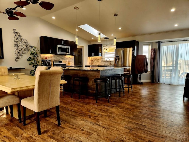 1044 S Los Charros Dr, Pueblo West, CO 81007 - dining space featuring a ceiling fan, lofted ceiling with skylight, recessed lighting, and dark wood-style floors