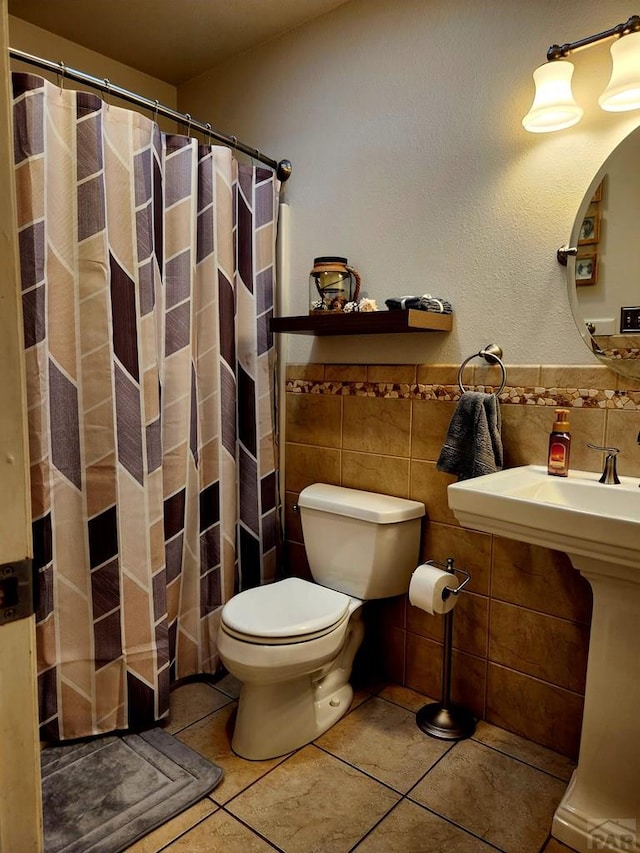 1044 S Los Charros Dr, Pueblo West, CO 81007 - full bath with tile patterned flooring, wainscoting, curtained shower, tile walls, and toilet