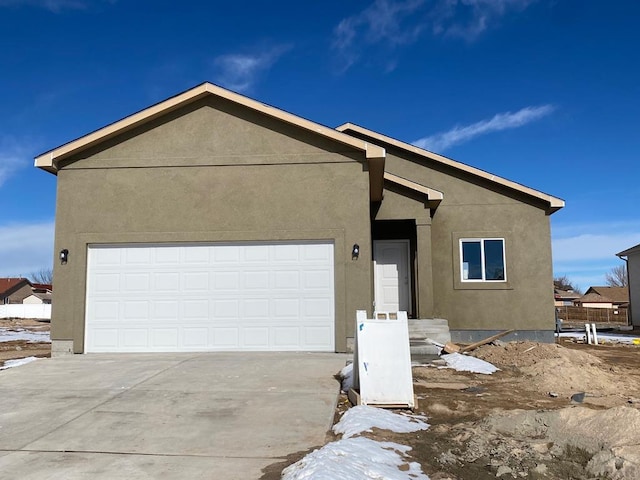 view of front of house with a garage, driveway, and stucco siding