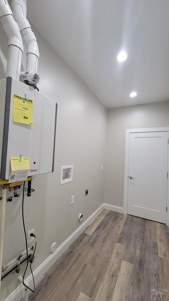 clothes washing area featuring washer hookup, wood finished floors, baseboards, hookup for an electric dryer, and laundry area