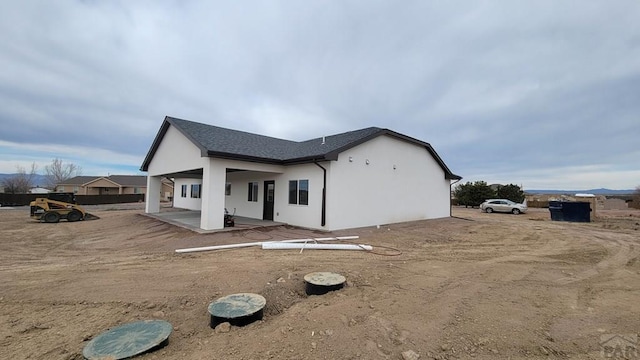 rear view of property with a patio and stucco siding