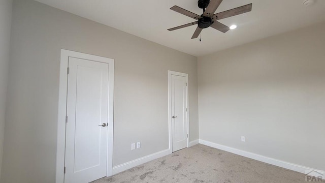 unfurnished bedroom featuring a ceiling fan, baseboards, and light carpet